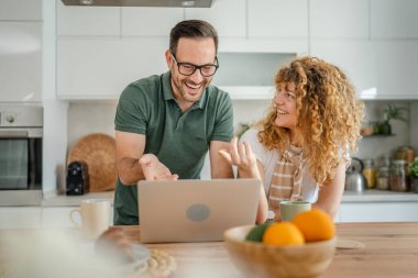 Mutlu çift Kafkasyalı yetişkin erkek ve kadın karı ve koca sabah rutini kahvaltıda evde fotokopi odasında dizüstü bilgisayar kullanın.