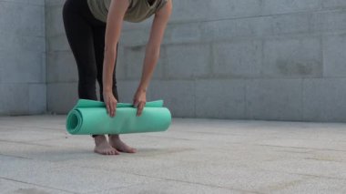 Meçhul kadın şehirdeki beton zemine yoga minderi serdi.