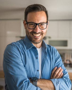 Bir yetişkin portresi, sakallı ve gözlüklü beyaz bir erkek. Mutlu bir gülümseme.