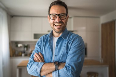 Bir yetişkin portresi, sakallı ve gözlüklü beyaz bir erkek. Mutlu bir gülümseme.