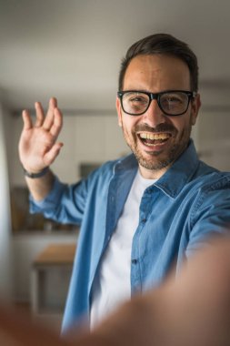 Bir yetişkin portresi, sakallı ve gözlüklü beyaz bir erkeğin mutlu bir gülümseme ile kendi portresinin fotokopisini çeker.