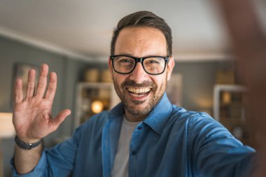 Bir yetişkin portresi, sakallı ve gözlüklü beyaz bir erkeğin mutlu bir gülümseme ile kendi portresinin fotokopisini çeker.