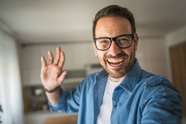 Bir yetişkin portresi, sakallı ve gözlüklü beyaz bir erkeğin mutlu bir gülümseme ile kendi portresinin fotokopisini çeker.