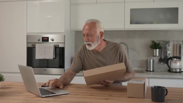 Een Senior Kaukasische Man Thuis Houden Kartonnen Doos Pakket Geleverd — Stockvideo