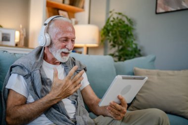 Son sınıf beyaz erkek emeklilerden biri evinde kanepede oturup film izlemek için dijital tablet kullanıyor ya da kafasında gri saç ve sakallı kulaklıkla internetten video görüşmesi yapıyor.
