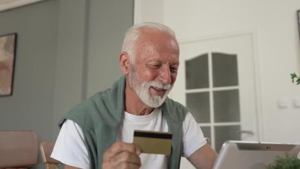 人の年長の白人男性の祖父は自宅で座ってクレジット カードを使用し デジタル タブレットのショッピング オンライン使用 オンライン購入のためのインターネット アクティブ モダン シニア — ストック動画