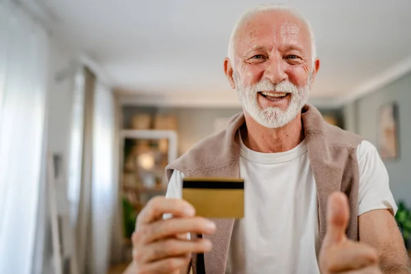 Portrait of senor man hold credit debit card online banking concept