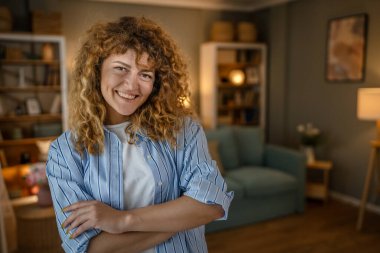 Yetişkin beyaz bir kadının portresi. Mutlu, kıvırcık saçlı.