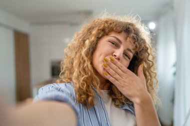 Yetişkin beyaz bir kadının portresi. Mutlu, kıvırcık saçlı.