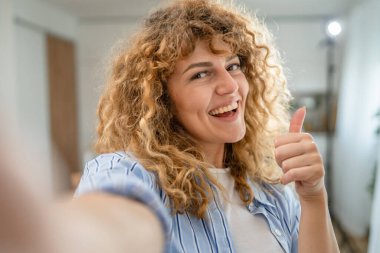 Yetişkin beyaz bir kadının portresi. Mutlu, kıvırcık saçlı.