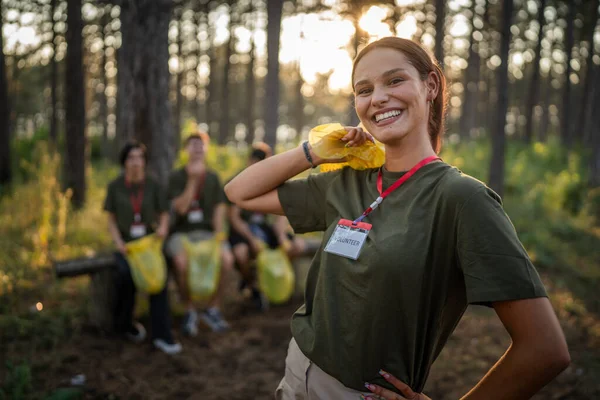 在阳光明媚的日间环境保护生态运动理念下 高加索女性青少年积极分子在从森林清洁自然中捡垃圾塑料瓶纸时的肖像 — 图库照片