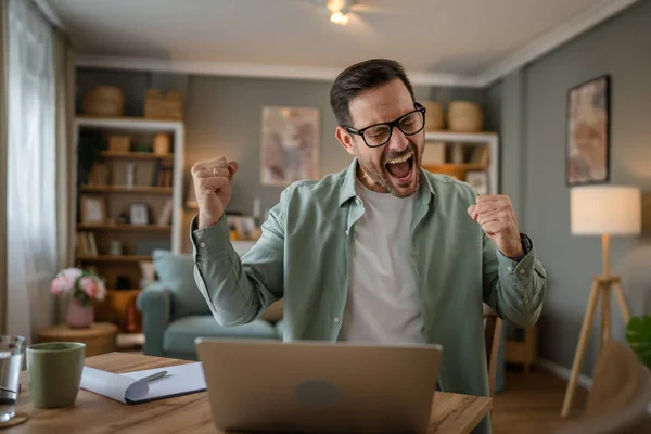 stock image one man adult caucasian male with beard work on his laptop computer at home happy smile success freelance entrepreneur or remote work concept