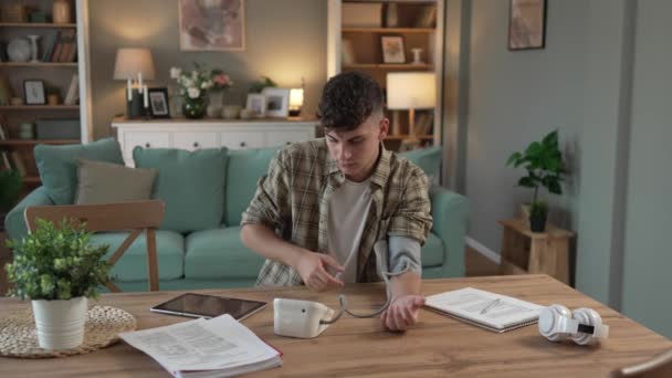 Kafkasyalı Genç Bir Adam Masada Oturuyor Kan Basıncını Ölçmek Için — Stok video