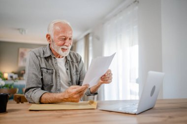 Beyaz tenli üst düzey bir adam banka hesap özeti, kredi onaylama sözleşmesi ya da iş sigortası haber davetiyesi alırken mektup ya da belge zarfını açarken