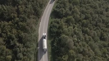 Sırbistan 'da yeşil ve manzara taşımacılığı ve seyahat konseptiyle çevrili dolambaçlı yol boyunca giden bahar aracı kamyonları sırasında bir dağ sırasındaki eğri asfalt bir yolun hava aracı görüntüleri