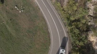 Sırbistan 'da yeşil ve manzara taşımacılığı ve seyahat konseptiyle çevrili dolambaçlı yol boyunca giden bahar aracı kamyonları sırasında bir dağ sırasındaki eğri asfalt bir yolun hava aracı görüntüleri