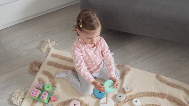 木製のおもちゃのある部屋で家で遊ぶ1人の白人少女トッドラー — ストック動画