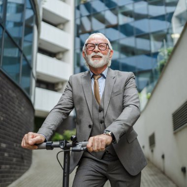Son sınıf beyaz erkek. Elektrikli scooterın üzerinde duruyor. Şehrin e-scooter çevre dostu ulaşım aracında sürüyor.