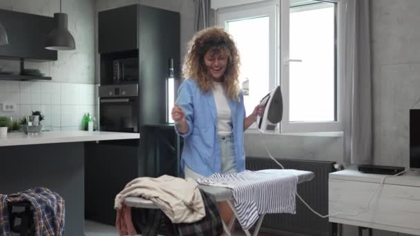 白种人成年女性快乐女性在家里用电熨斗熨烫衣服家务活的概念真正的人做家务活动作缓慢 — 图库视频影像