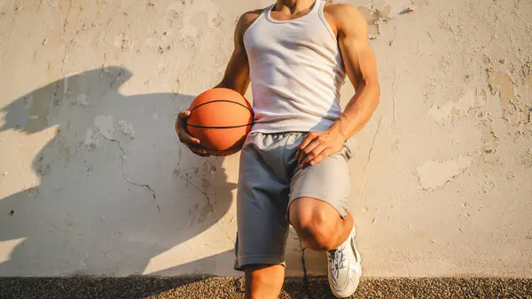 若い白人男性アスリートスタンド屋外ホールドバスケットボールボールウェア白いタンクトップ シャツ強力な筋肉本人のコピースペース幸せな笑顔自信を持って健康的なライフスタイルのコンセプト — ストック写真