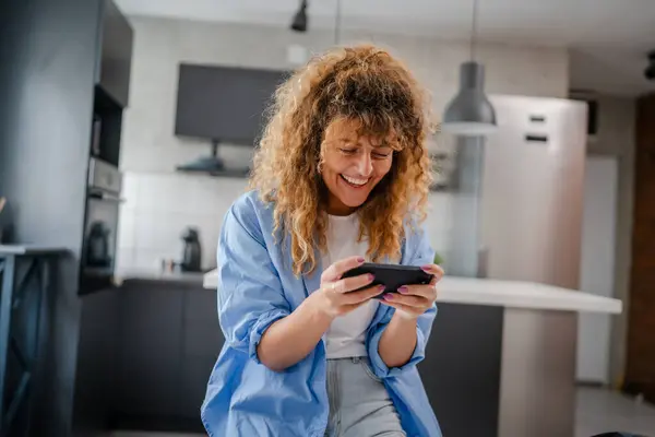 Yetişkin Bir Beyaz Kadın Evde Akıllı Telefonuyla Video Oyunu Oynarken — Stok fotoğraf