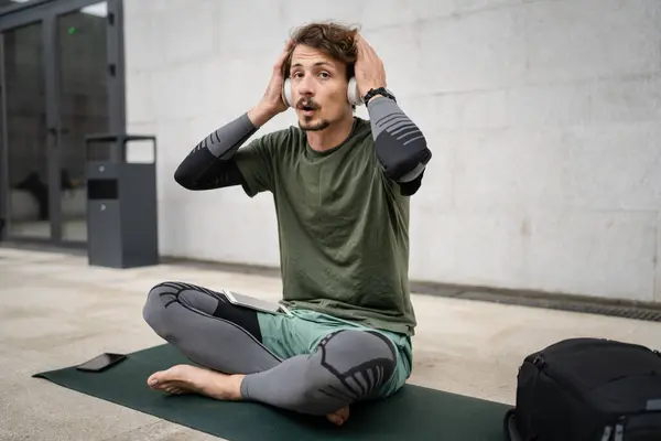 Genç Yetişkin Beyaz Bir Erkek Kulaklıkla Dışarıda Otururken Yoga Meditasyona — Stok fotoğraf