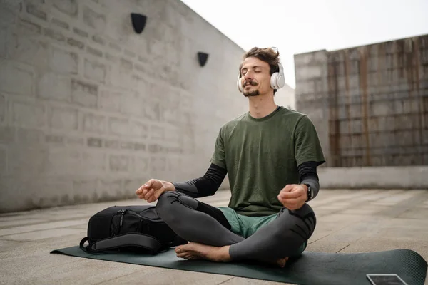 Genç Yetişkin Beyaz Bir Erkek Yoga Meditasyon Için Kapalı Kulaklıkla — Stok fotoğraf