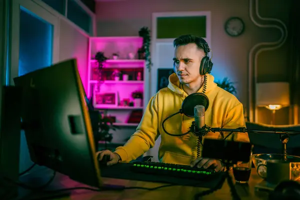 Young man play video games on pc computer while streaming to social media or internet online video male gamer at home wear headphone frustrated losing copy space
