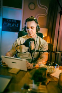 One man caucasian male blogger or vlogger gesticulating while streaming video podcast in broadcasting studio use microphone and headphones famous influencer shooting video for channel podcast