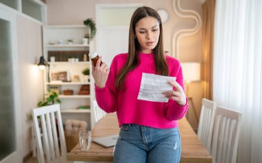 one young woman read medical prescription hold medicine drugs at home