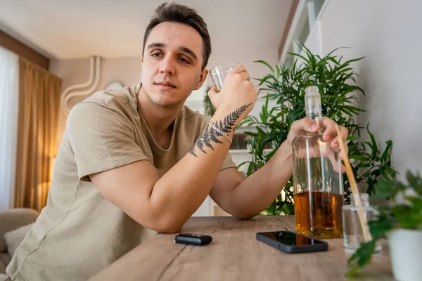 Bir Adam Evde Bir Şişe Likörle Oturup Viski Içiyor Alkollü — Stok fotoğraf