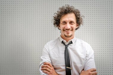 Kafkasyalı yetişkin bir adamın portresi açık havada durur beyaz gömlek giyer ve kravat takar mutlu bir gülümseme takınır fotokopi alanı duvarın önünde durur kendine güvenen bir işadamı modern binanın önünde poz verir.