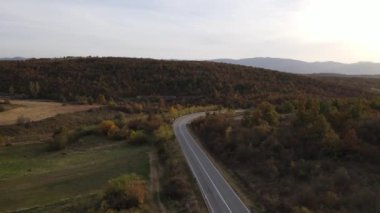 Araç, sonbahar günü dağlık alanda hava manzaralı yolculuk yapar.