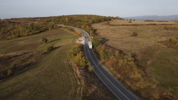 セルビアのトリバババ クズゼワク山で秋の山の範囲の木々と森を駆動する道路トラックの空中視界ドローン画像 — ストック動画