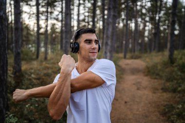 Bir erkek beyaz erkek sporcu ormanda doğada koşuyor ya da sonbaharda ya da yaz günlerinde spor yapıyor spor yapıyor spor yapıyor sağlıklı yaşam tarzı kavramı gerçek insanlar mekanı kopyalıyor.