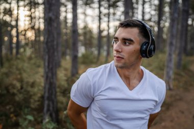 Bir erkek beyaz erkek sporcu ormanda doğada koşuyor ya da sonbaharda ya da yaz günlerinde spor yapıyor spor yapıyor spor yapıyor sağlıklı yaşam tarzı kavramı gerçek insanlar mekanı kopyalıyor.