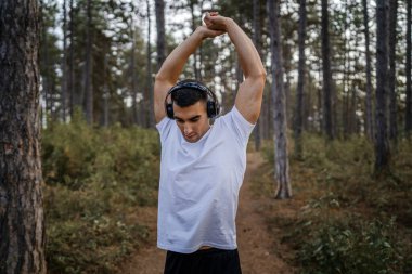 Bir erkek beyaz erkek sporcu ormanda doğada koşuyor ya da sonbaharda ya da yaz günlerinde spor yapıyor spor yapıyor spor yapıyor sağlıklı yaşam tarzı kavramı gerçek insanlar mekanı kopyalıyor.