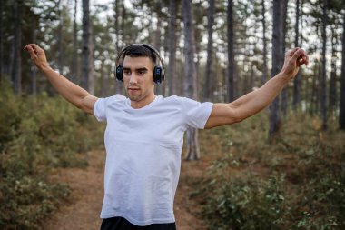 Bir erkek beyaz erkek sporcu ormanda doğada koşuyor ya da sonbaharda ya da yaz günlerinde spor yapıyor spor yapıyor spor yapıyor sağlıklı yaşam tarzı kavramı gerçek insanlar mekanı kopyalıyor.