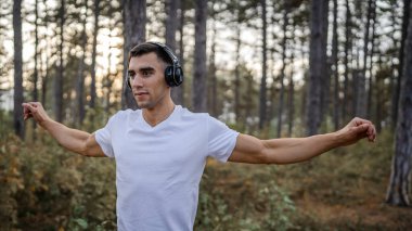 Bir erkek beyaz erkek sporcu ormanda doğada koşuyor ya da sonbaharda ya da yaz günlerinde spor yapıyor spor yapıyor spor yapıyor sağlıklı yaşam tarzı kavramı gerçek insanlar mekanı kopyalıyor.