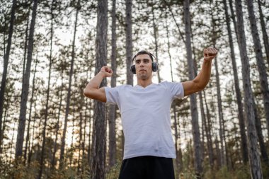 Bir erkek beyaz erkek sporcu ormanda doğada koşuyor ya da sonbaharda ya da yaz günlerinde spor yapıyor spor yapıyor spor yapıyor sağlıklı yaşam tarzı kavramı gerçek insanlar mekanı kopyalıyor.
