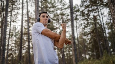 Bir erkek beyaz erkek sporcu ormanda doğada koşuyor ya da sonbaharda ya da yaz günlerinde spor yapıyor spor yapıyor spor yapıyor sağlıklı yaşam tarzı kavramı gerçek insanlar mekanı kopyalıyor.