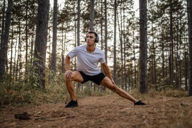 Bir erkek beyaz erkek sporcu ormanda doğada koşuyor ya da sonbaharda ya da yaz günlerinde spor yapıyor spor yapıyor spor yapıyor sağlıklı yaşam tarzı kavramı gerçek insanlar mekanı kopyalıyor.