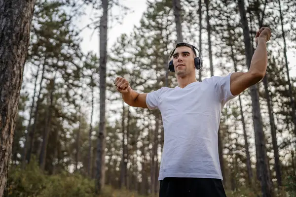 Bir erkek beyaz erkek sporcu ormanda doğada koşuyor ya da sonbaharda ya da yaz günlerinde spor yapıyor spor yapıyor spor yapıyor sağlıklı yaşam tarzı kavramı gerçek insanlar mekanı kopyalıyor.