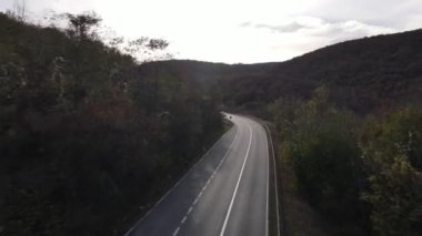 Araç, sonbahar günü dağlık alanda hava manzaralı yolculuk yapar.