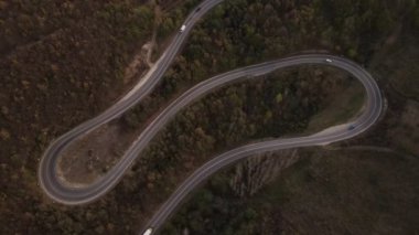 Araç, sonbahar günü dağlık alanda hava manzaralı yolculuk yapar.