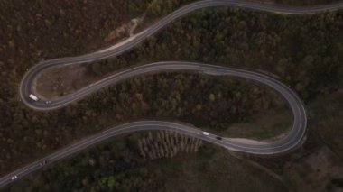 Araç, sonbahar günü dağlık alanda hava manzaralı yolculuk yapar.