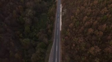 Araç, sonbahar günü dağlık alanda hava manzaralı yolculuk yapar.