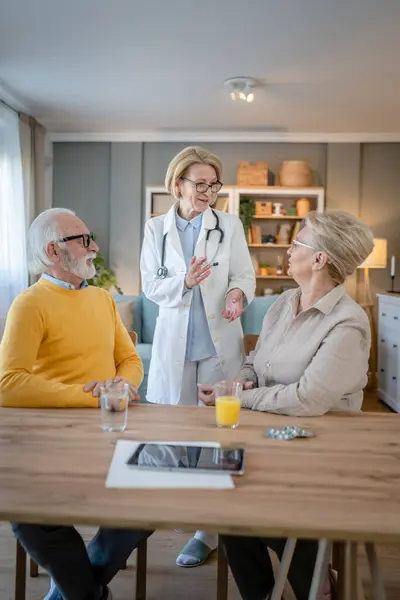 Mature woman doctor visit senior couple man and female husband and wife having a talk and consulting about diagnosis and medical medication treatment real people healthcare concept copy space
