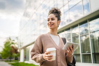 Genç yetişkin bir kadın beyaz kadın dışarıda durup mutlu bir portre çiziyor.