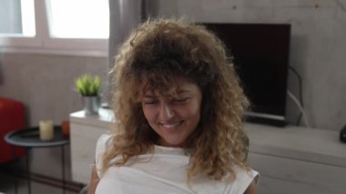 Beyaz bir kadın evde ders çalışıyor. Sınav kağıtlarını okuyup hazırlıyor. Gerçek insanlar kanepede otururken ellerinde kağıt belgeler ya da mektuplar tutuyor. 